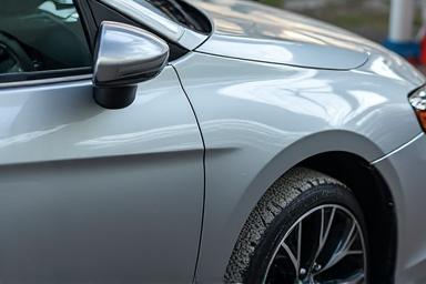 A gleaming silver car freshly cleaned by the CleanHub Express wash package.